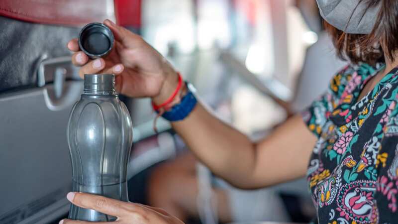 A woman said some boys sitting behind her on a plane poured something in her water bottle (Stock photo) (Image: Getty Images/iStockphoto)