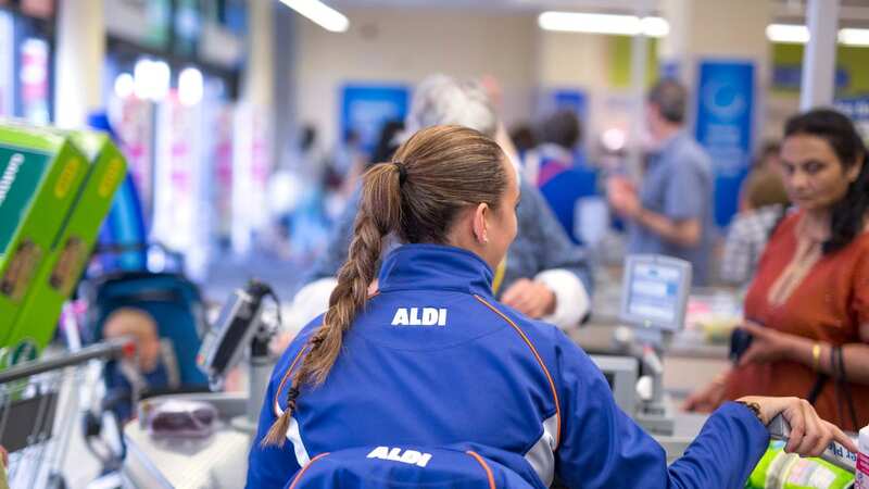 A member of staff prepares to scan goods at a checkout at an Aldi in London (file image) (Image: Bloomberg via Getty Images)