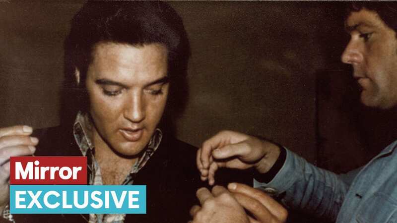 Jerry helps Elvis put on a necklace given to him by a fan in 1974 (Image: DAILY MIRROR)