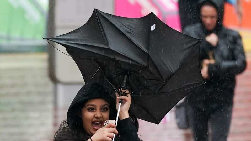 A woman struggles with her umbrella during wet and windy conditions in Birmingham recently (Image: PA)