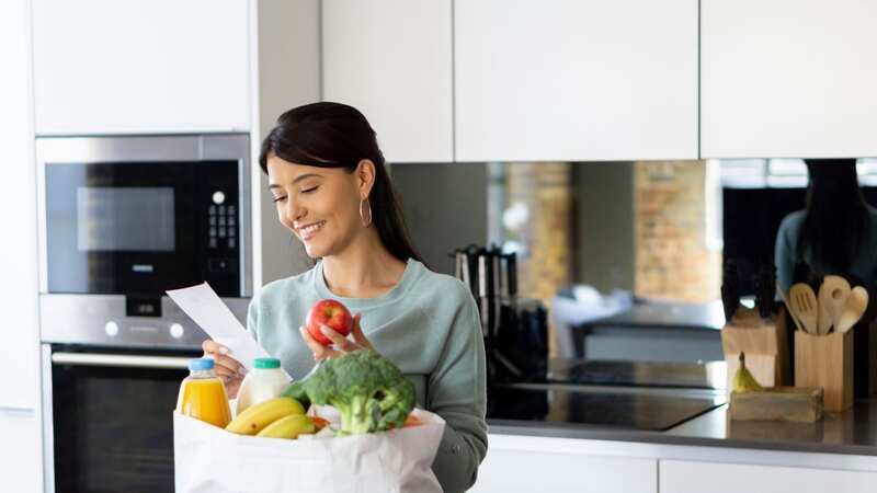 A woman at home after grocery shopping (stock) (Image: Getty Images)