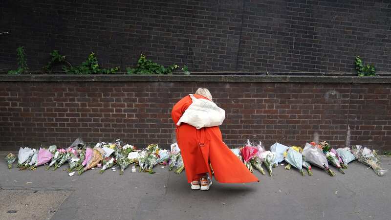 A woman lays flowers near the scene in Croydon, south London, where a 15-year-old girl was stabbed to death on Wednesday (Image: PA Wire/PA Images)