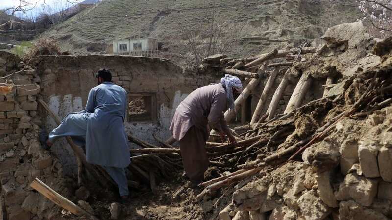 Residents clear debris from a damaged house in Afghanistan