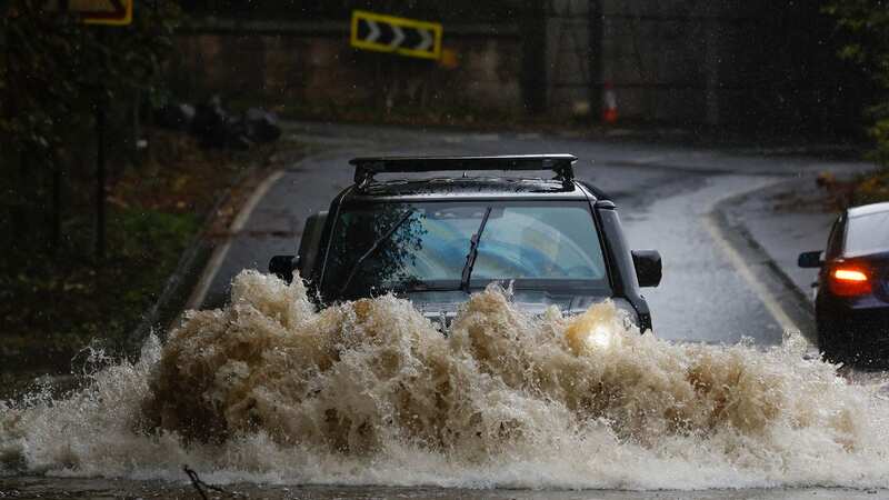 A car drives through floodwater in Dumbarton, Scotland (Image: Getty Images)