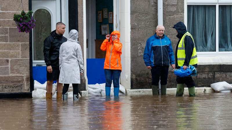 Members of the public struggle with flooding yesterday in Dumbarton, West Dunbartonshire (Image: Getty Images)