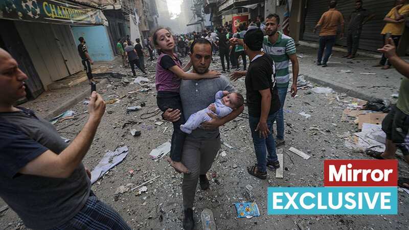 A man holding a young girl and a baby runs from the site of an Israeli rocket attack in Al- Shati refugee camp in the west of Gaza City (Image: MOHAMMED SABER/EPA-EFE/REX/Shutterstock)