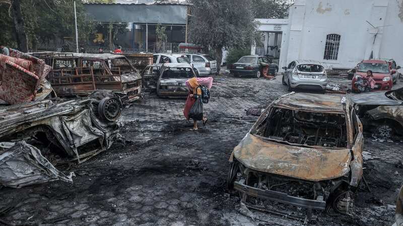 A boy tries to collect usable belongings amid wreckage of vehicles after Al-Ahli Baptist Hospital was hit in Gaza (Image: Anadolu via Getty Images)