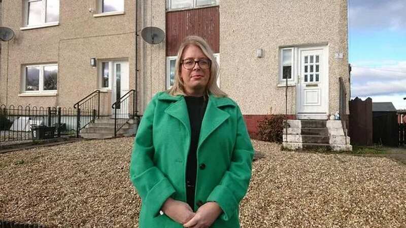 Councillor Claire Mackie-Brown outside the Limerigg house where the tenant faces a £12,000 bill (Image: LDRS)