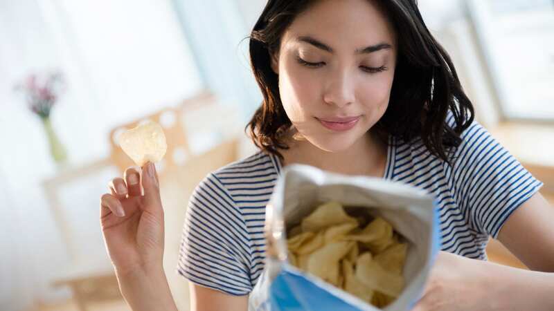 Savoury snacks such as crisps are known to dehydrate the body and increase water retention, making sleep more likely to be ‘superficial’ and disrupted. (Image: Getty Images/Tetra images RF)