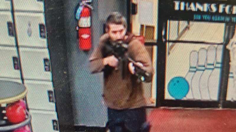 CCTV shows the armed suspect entering the bowling alley brandishing a rifle (Image: Androscoggin County Sheriff