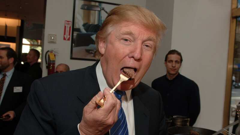 Trump is apparently happily preoccupied with his steak - and 