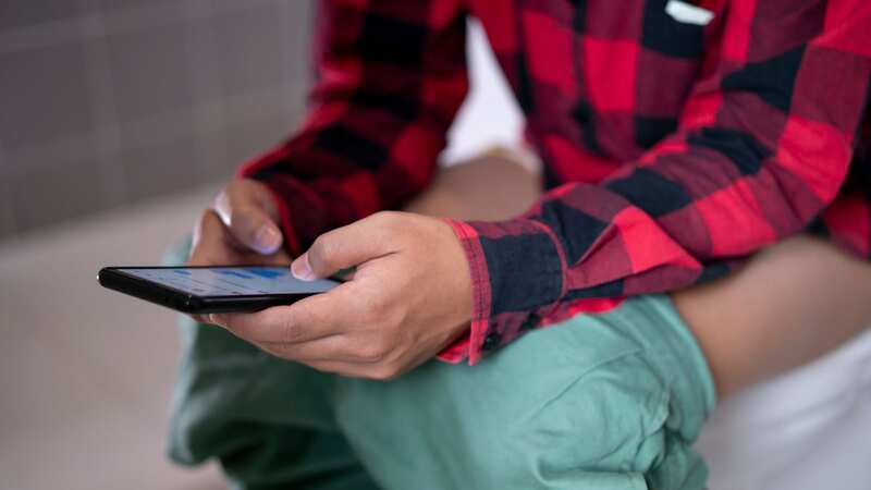A doctor has warned against sitting on the toilet with your phone (stock image) (Image: Getty Images)