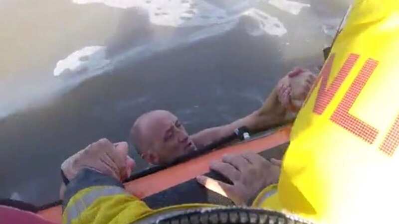 Dramatic moment exhausted swimmer is plucked from sea by rescue lifeboat