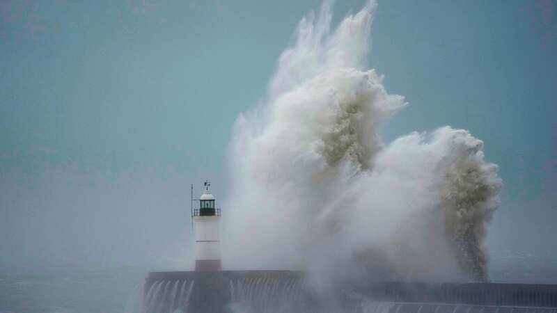 Waves crash over Newhaven Lighthouse in southern England (Image: AP)