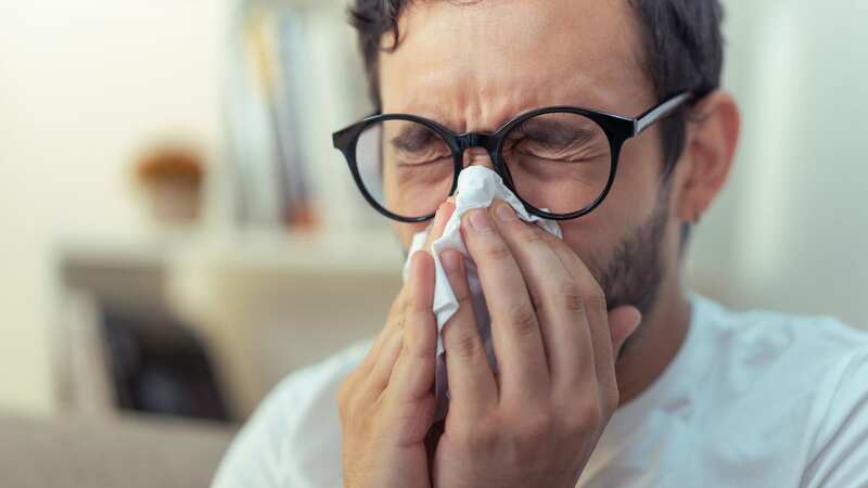 Doctors have warned of five health risks that can arise from holding in a sneeze (Image: Getty Images)