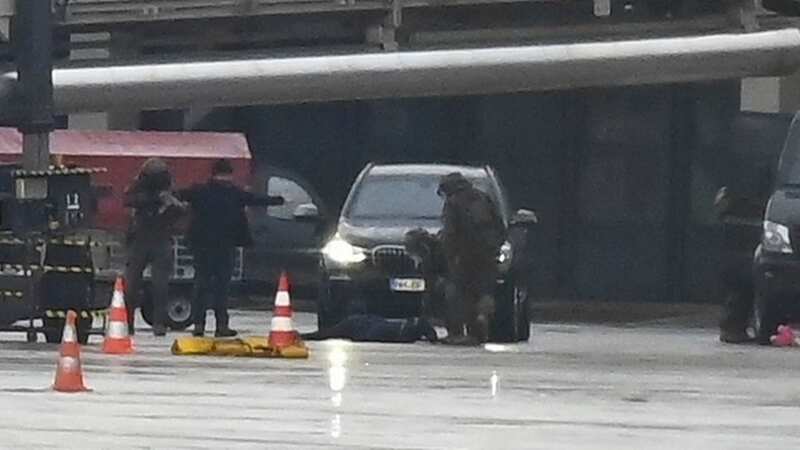 The man lies on the ground at the airport, surrounded by police (Image: Jonas Walzberg/picture-alliance/dpa/AP Images)