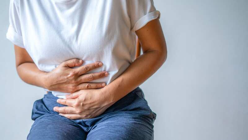 A woman struggles with a stomach ache (file image) (Image: Getty Images)
