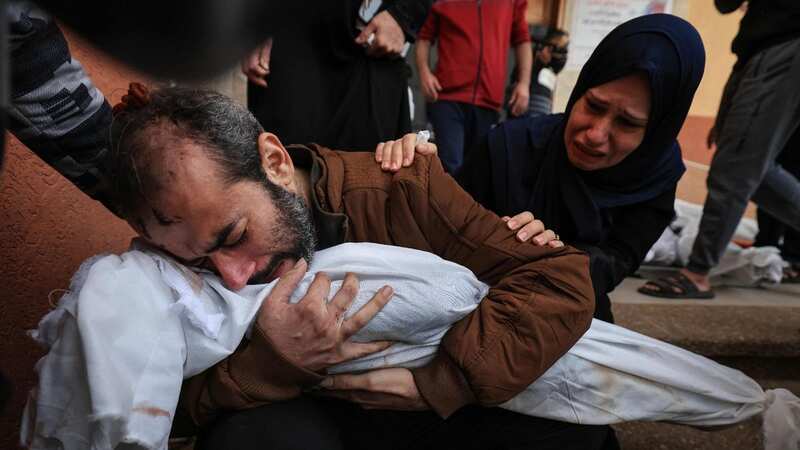 Fighting has resumed in Gaza. A man can be seen holding the corpse of one of his two children slaughtered in an Israeli air strike (Image: AFP via Getty Images)