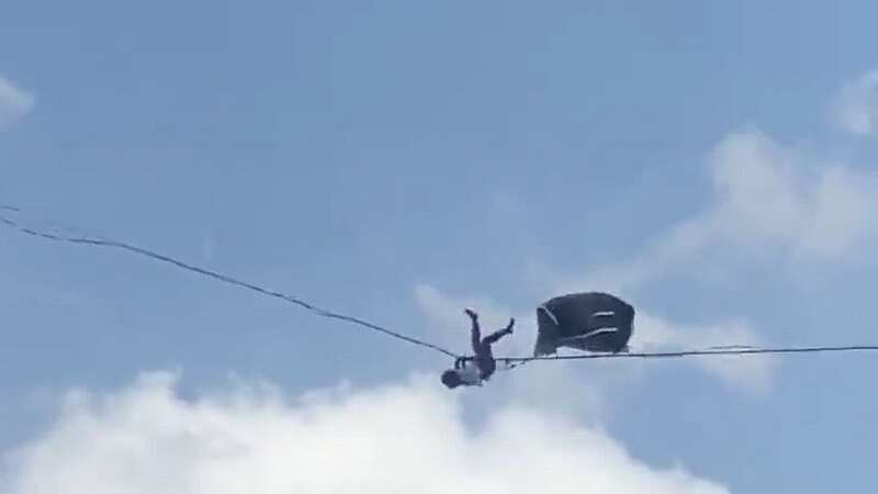 Daredevil tumbles off tightrope stretched between tower blocks 200ft in the air