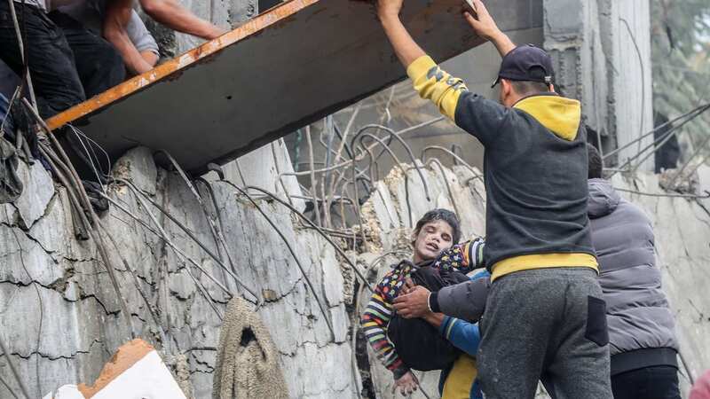 Rescuers pull child to safety yesterday (Image: Getty Images)