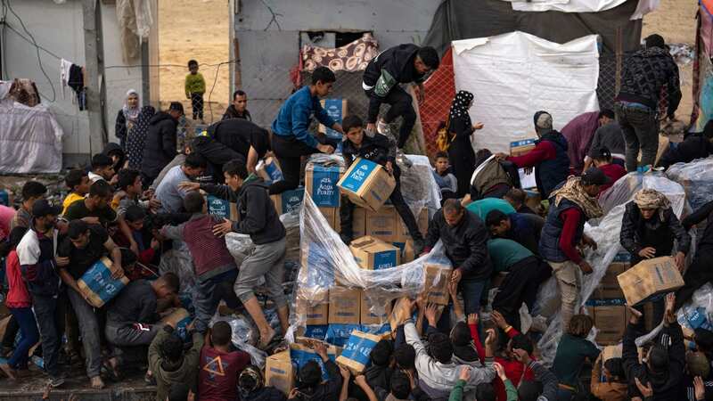 Palestinians loot a humanitarian aid truck as it crossed into the Gaza Strip in Rafah, today (Image: AP)