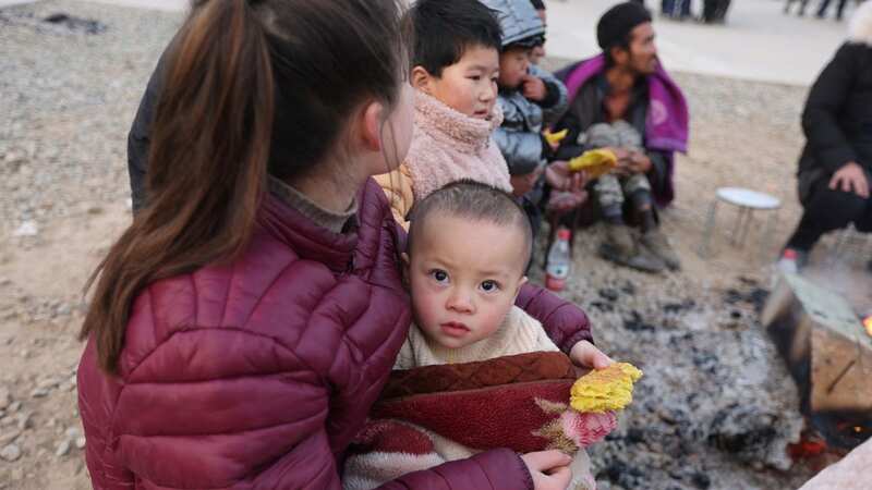 Residents gather outdoors the morning after an earthquake in Dahejia, Jishishan County, in northwest China