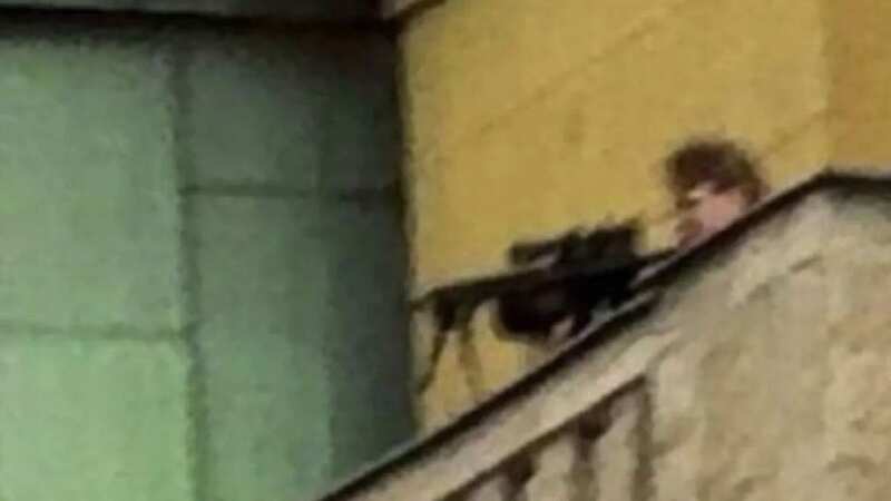 The suspected shooter is pictured on a balcony (Image: Twitter)