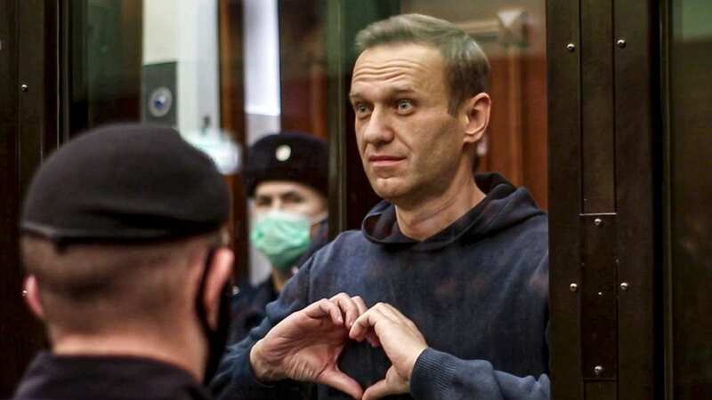 Russian opposition leader Alexei Navalny makes a heart gesture standing in a cage (Image: AP)