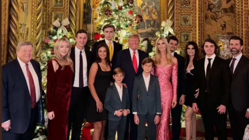 Barron Trump towers over his dad Donald in the Christmas photo (Image: Kimberly Guilfoyle/Instagram)