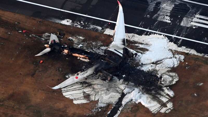 Burnt out wreck of plane seen on runway after being destroyed by huge fireball