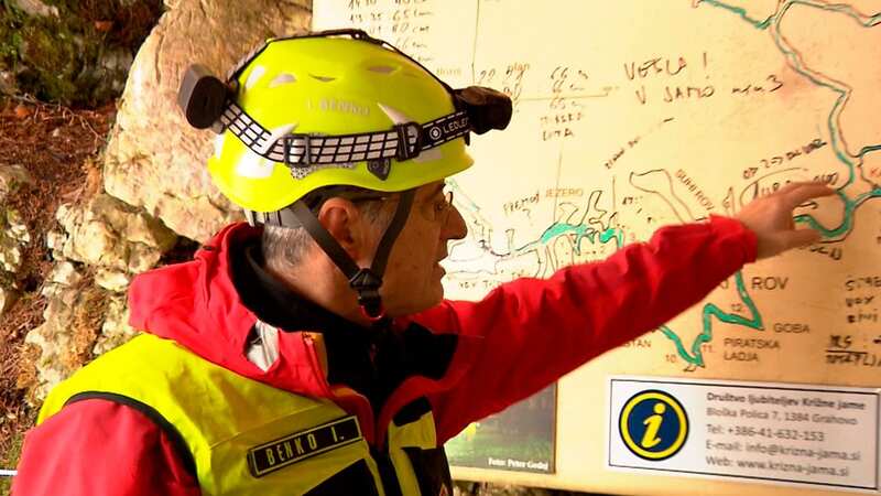 A rescuer inspects the map of the Krizna Jama cave near Grahovo, Slovenia earlier today (Image: AP)