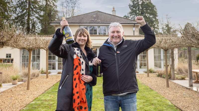 Michael Maher and his wife Amanda outside the £3million house in Somerset (Image: Omaze / SWNS)