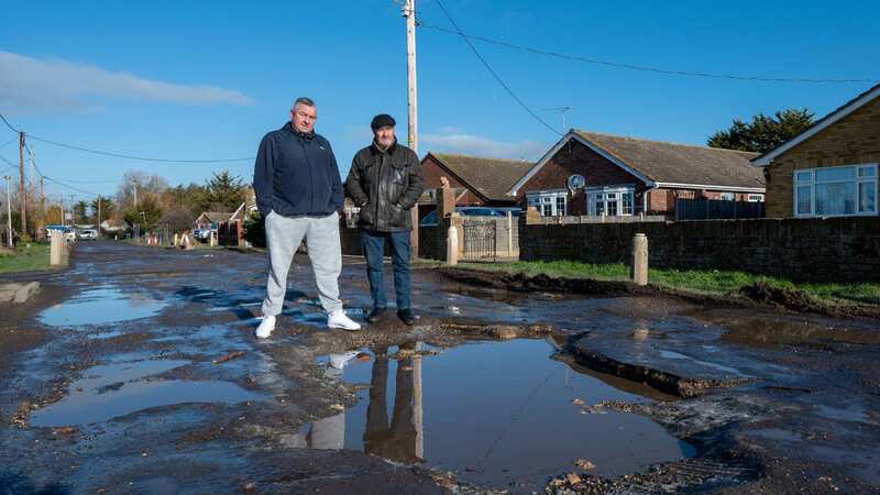 Two residents stand by large potholes on Seawick Road (Image: James Linsell-Clark/ SWNS)