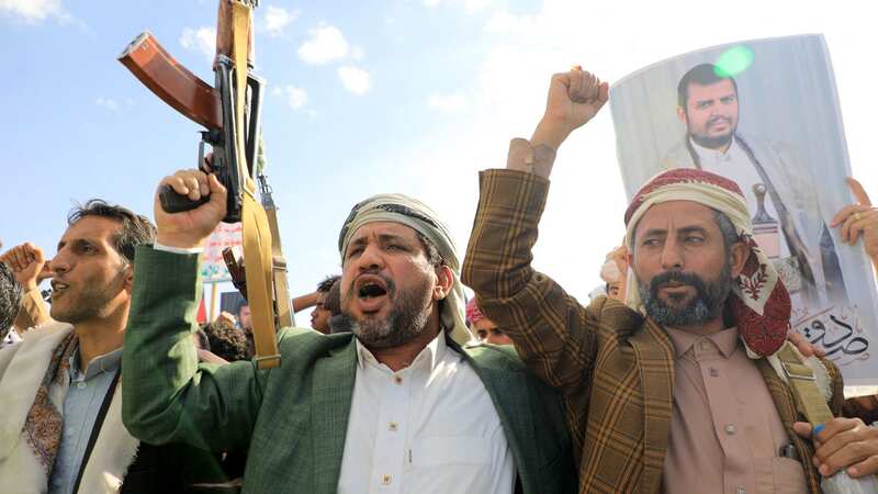 Yemeni men brandish their weapons and hold up portraits of Huthi leader Abdul Malik al-Houthi (Image: AFP via Getty Images)