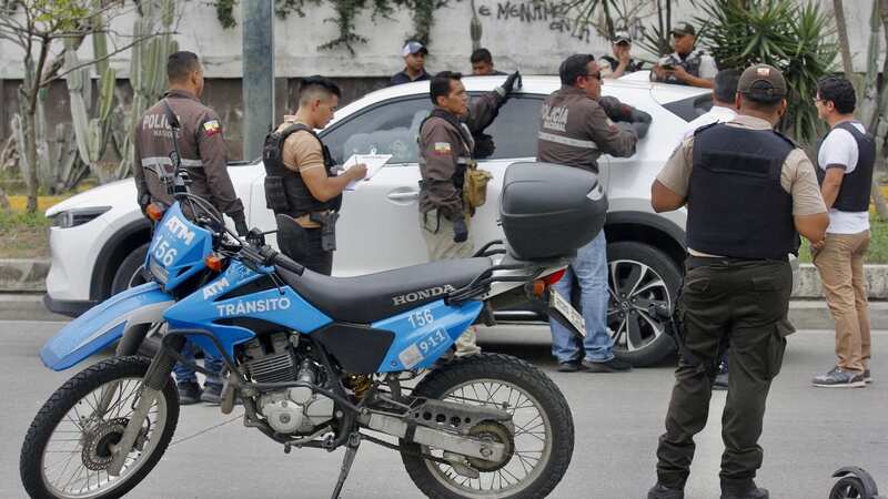 Members of the National Police inspect the car in which Prosecutor Cesar Suarez was shot dead (Image: AFP via Getty Images)