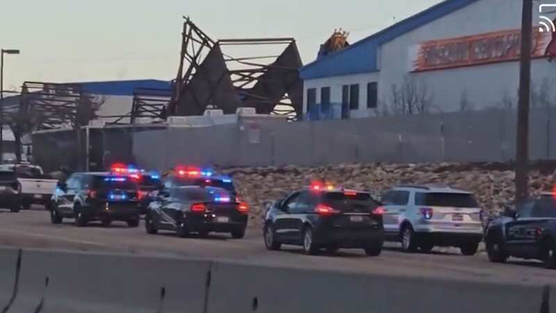 Footage from the scene showed a large number of police cars lined up at the side of the road with what appeared to be a mangled pile of metal and building material set back from the road (Image: No credit)