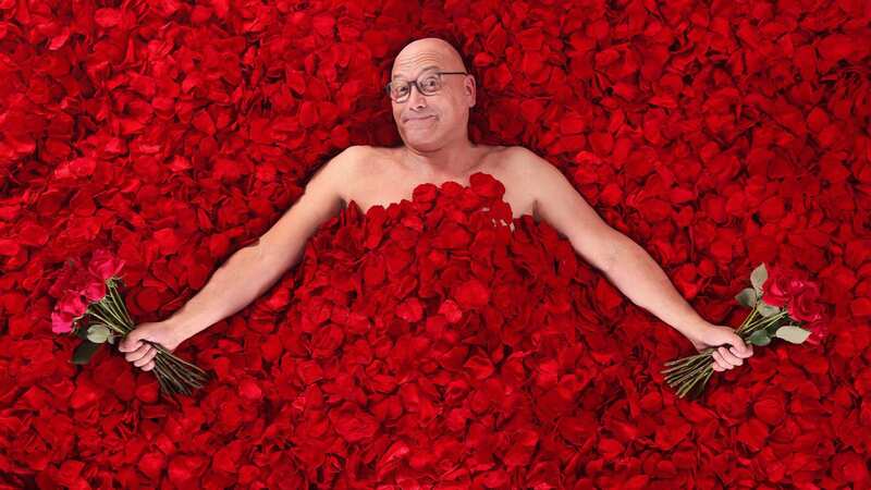 Gregg Wallace poses on a bed of roses ahead of handing out the flowers for free on London