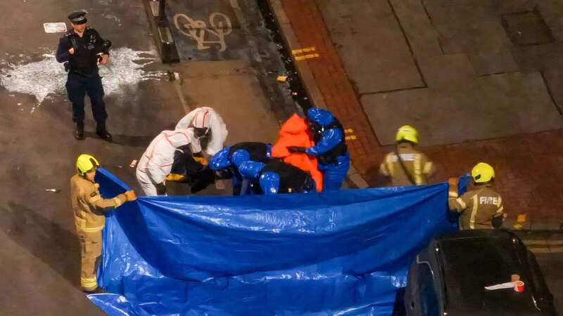 The man was held behind a blue cover (Image: UKNIP)