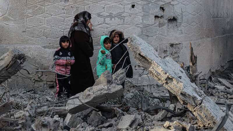 Palestinians walk amid the rubble of damaged buildings following the Israeli bombardment in Rafah (Image: AFP via Getty Images)