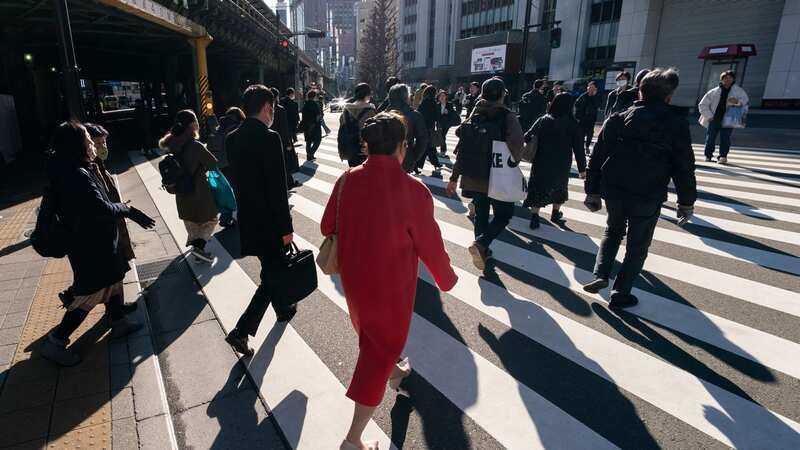 Commuters walk across a road in Tokyo, Japan. This week the government reported that the economy has slipped into recession (Photo by Tomohiro Ohsumi/Getty Images)