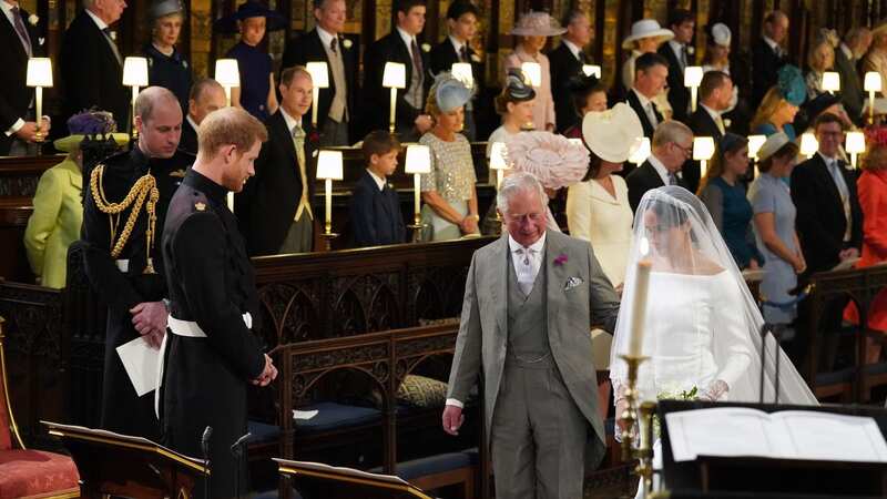 King Charles walks Meghan Markle down the aisle on her wedding day (Image: POOL/AFP via Getty Images)