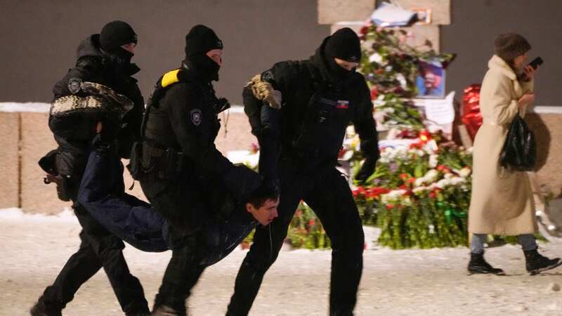 Police officers drag away a mourner in St. Petersburg, Russia on Friday (Image: AP)