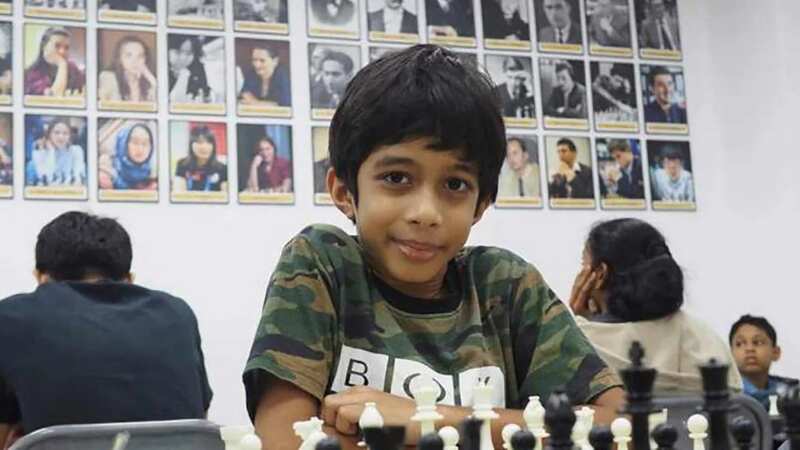 Ashwath Kaushik, 7, has to use a booster cushion to reach the chess board