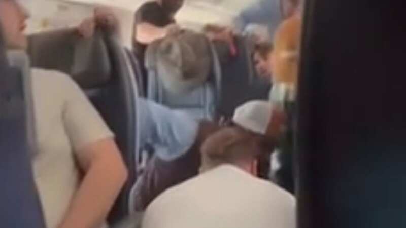 An unruly American Airlines passenger was tackled to the floor after he attempted and briefly succeeded in opening the emergency door of the aircraft, video shows (Image: No credit)
