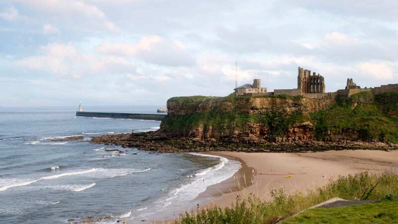 The castle ruins stand over the beach (Image: Getty Images/iStockphoto)