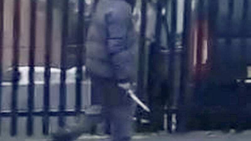 Chilling moment hooded knifeman walks past school while brandishing huge blade