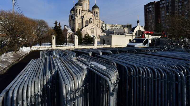 Workers unload metal fencing in front of the church in Moscow where Alexei Navalny