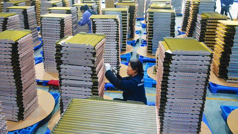 Workers labor at a factory of coolant radiators for air conditioners in Yuexi county in central China