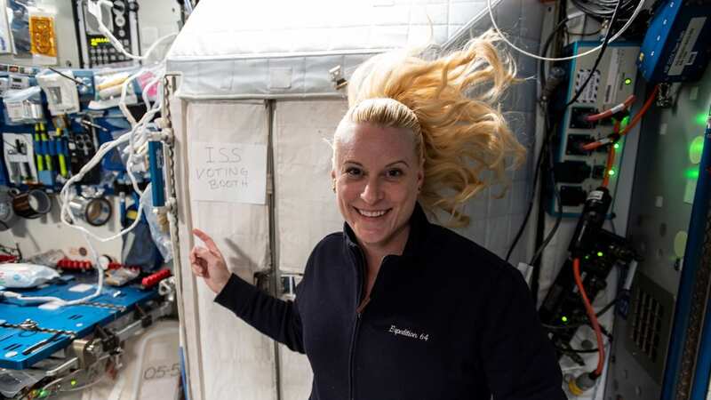 NASA astronaut Kate Rubins points to the International Space Station’s “voting booth” where she cast her vote from space (Image: NASA)