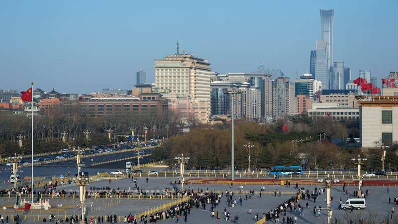 Visitors tour Tiananmen Square as high-rise office buildings of Central Business District are seen in the background, in Beijing (Image: Copyright 2024 The Associated Press. All rights reserved)